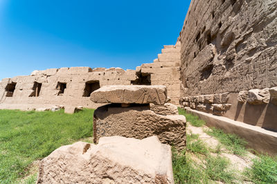 Low angle view of old ruins against blue sky