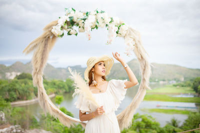 Full length of a beautiful young woman standing against white wall