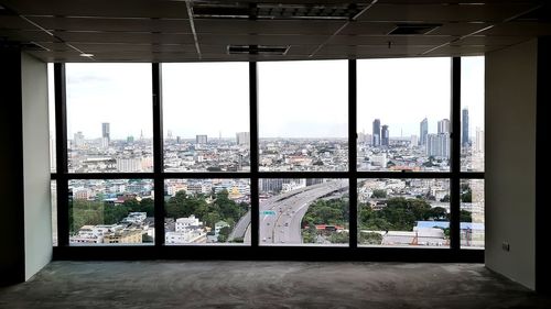 Trees and buildings seen through glass window