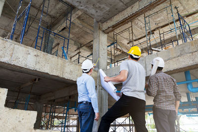 Rear view of engineers working at construction site