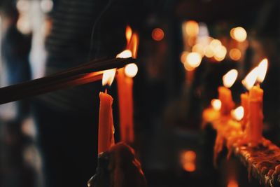 Close-up of illuminated lit candles at church