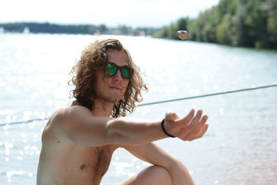 Young man throwing pebble in the air