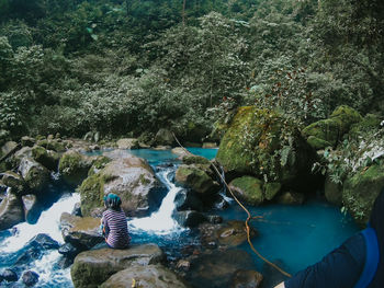 Man sitting on rock by water