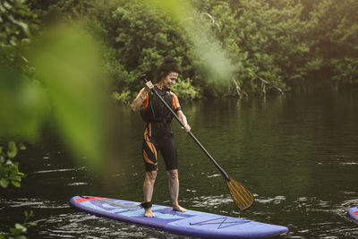Man standing on boat in lake