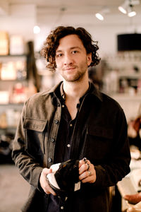 Portrait of male customer buying shoe at retail store