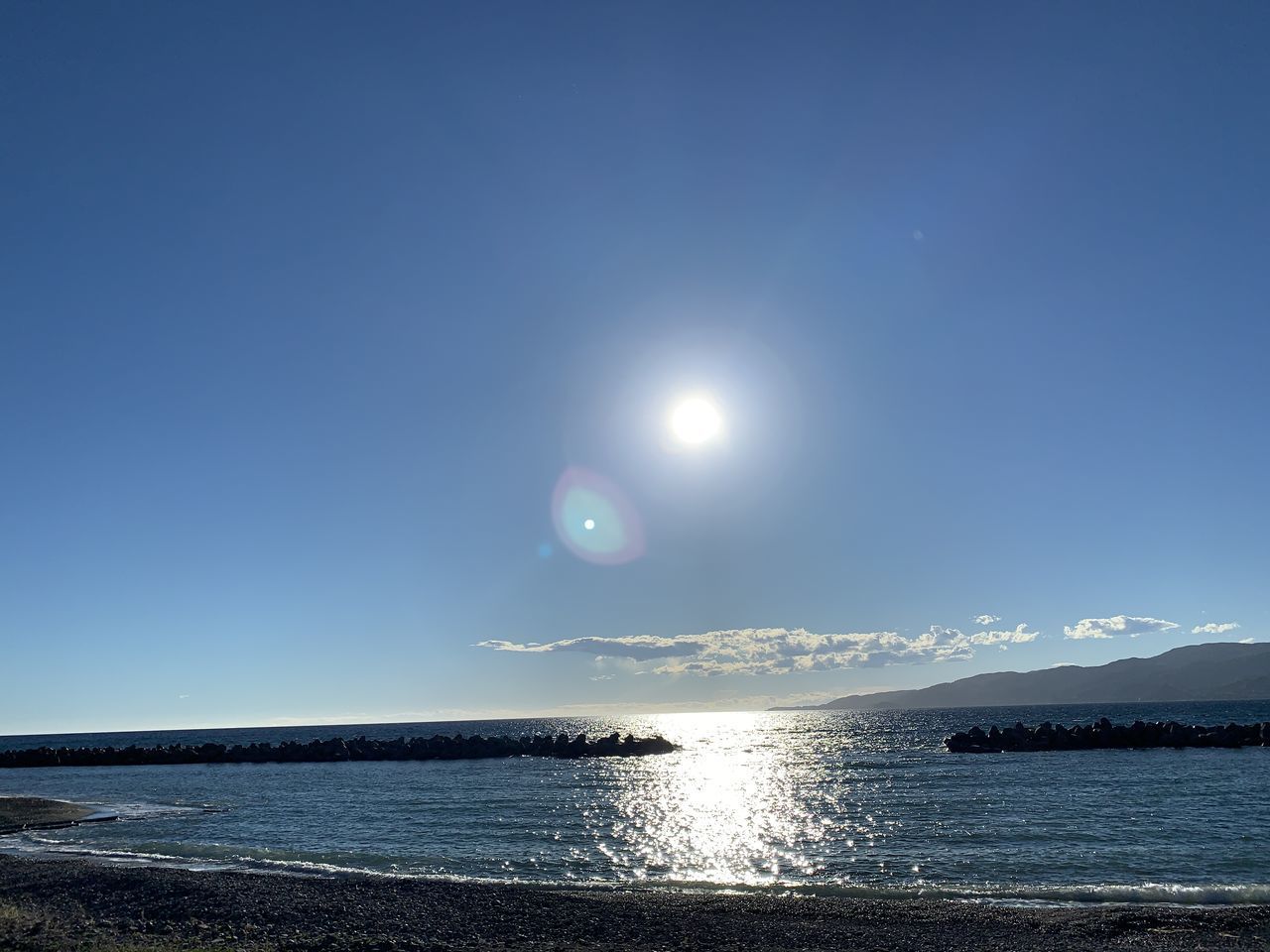 SCENIC VIEW OF SEA AGAINST BRIGHT SUN IN SKY