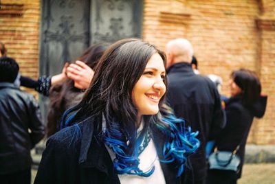 Smiling beautiful woman with people standing in background