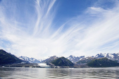 Scenic view of sea and snowcapped mountains against sky