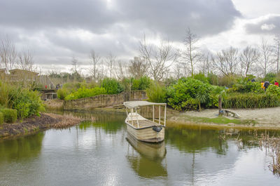 Boat moored in lake against sky