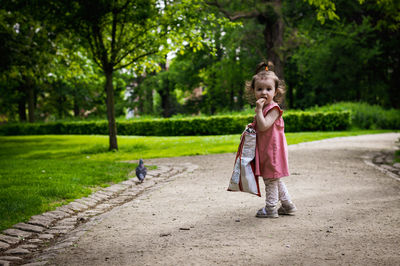 Portrait of a baby girl eating chips in the park.