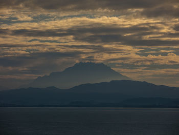 A silhouette of a mount kinabalu in sabah malaysia during a morning light from the sea 