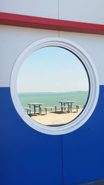 Scenic view of sea against blue sky seen through window