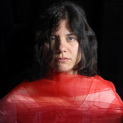 Portrait of young woman against black background