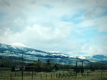 Scenic view of snow covered mountains against cloudy sky