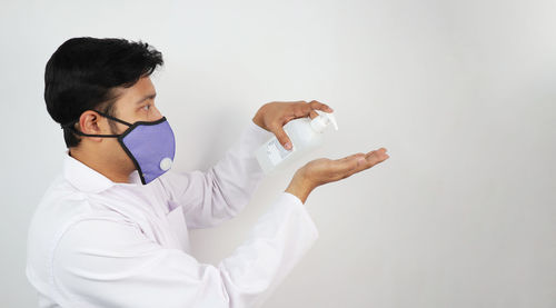 Young man wearing mask against white background