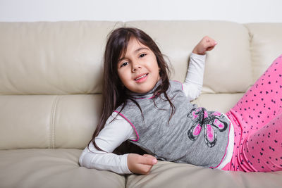 Portrait of smiling girl on sofa at home