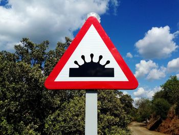 Close-up of road sign against sky