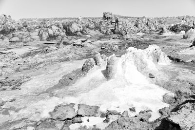 Scenic view of rocks in sea against sky