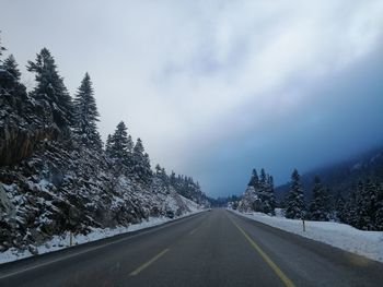 Road amidst trees against sky