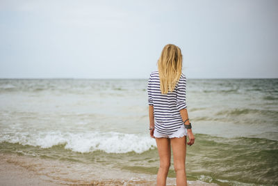 Rear view of woman standing on beach