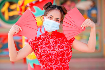 Woman wearing mask while holding papers