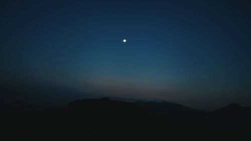 Scenic view of silhouette mountains against sky at night