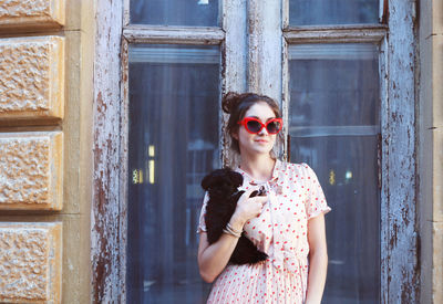 Portrait of young woman wearing sunglasses standing outdoors