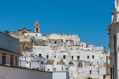 Buildings in town against clear blue sky