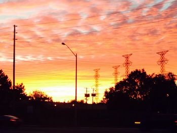 Electricity pylon against sky at sunset