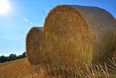 Hay bales on field against sky
