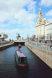 Boat sailing on river in city