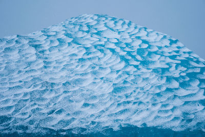 Close-up of frozen sea against blue background