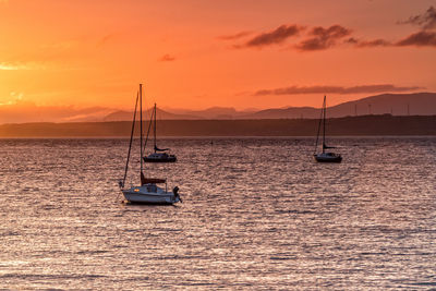 Sailboat on sea against sky during sunset