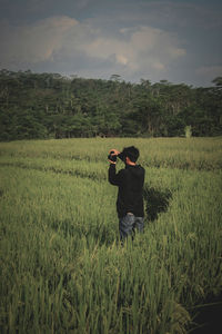Man photographing on field