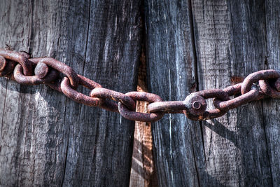 Close-up of rusty chain on wood