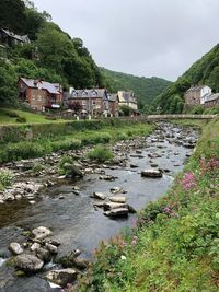 Scenic view of river by buildings against sky