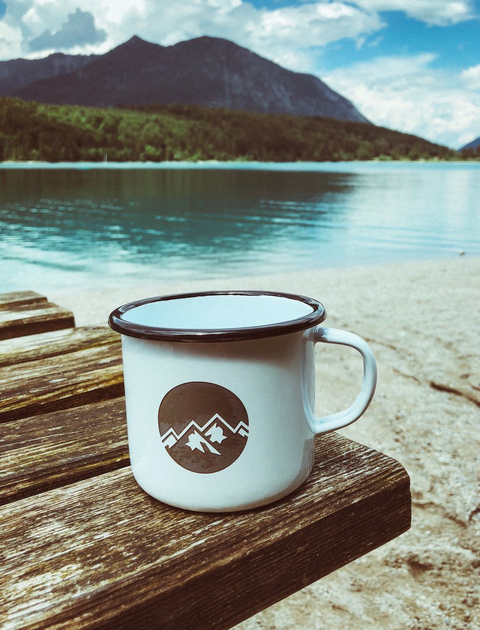 cup, mug, food and drink, drink, mountain, table, no people, refreshment, water, coffee cup, lake, nature, day, close-up, coffee, tea, hot drink, coffee - drink, reflection, outdoors, tea cup, crockery