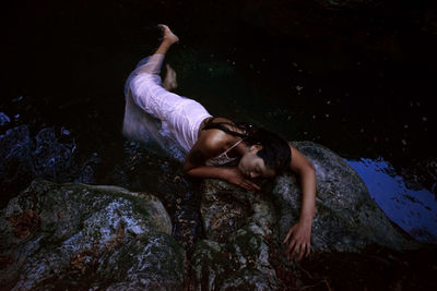 Young woman lying on rock