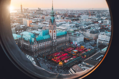 High angle view of buildings in city seen through glass window