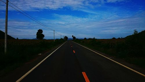 Road amidst trees against sky