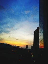 Silhouette buildings against sky at sunset