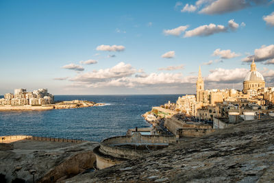 Panoramic view of sea and buildings against sky