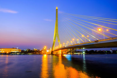 Suspension bridge over river at night