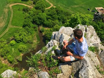 Full length of man sitting on rock