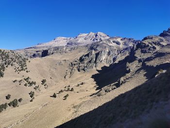 Scenic view of rocky mountains against clear blue sky