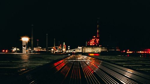 Illuminated buildings in city against clear sky at night