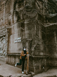 Woman standing on wall with text