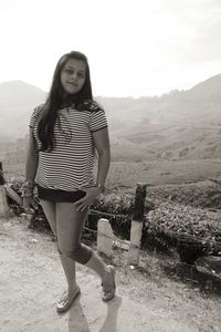 Portrait of a smiling young woman standing on mountain