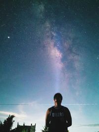 Rear view of man looking at night sky