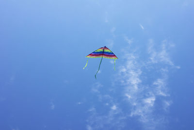 Low angle view of kite flying against blue sky